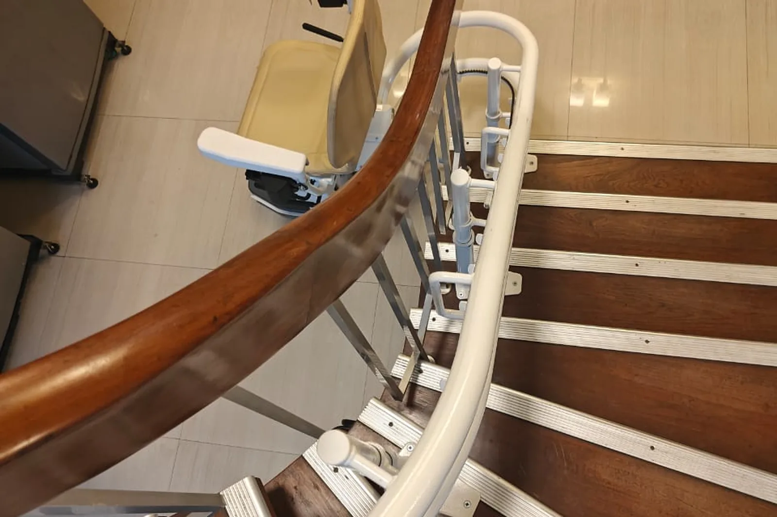 Treppenlift an einer eleganten gewendelten Holztreppe