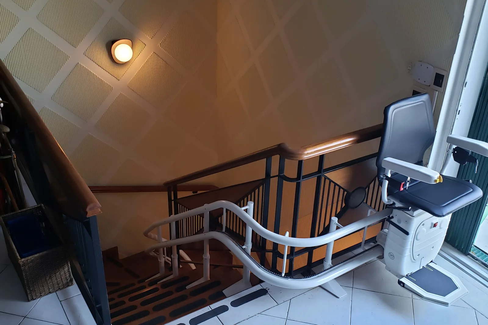 Treppenlift-Schiene an einer gefliesten Treppe von unten gesehen