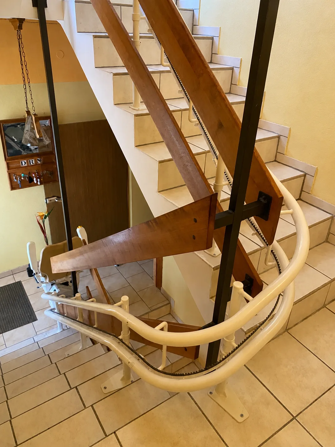 Kurvenlift-Referenz: Detailansicht der Doppelrohr-Kurvenschiene entlang des Geländers einer gefliesten Treppe