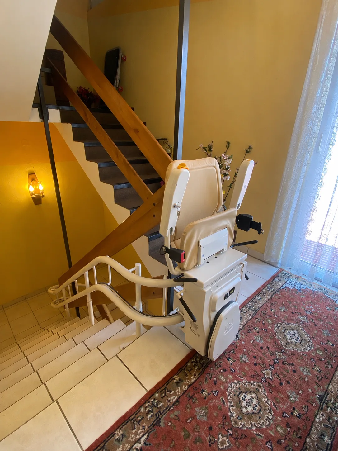 Kurvenlift-Referenz: Verlauf der weißen Kurvenschiene über mehrere Podeste einer gefliesten Innentreppe