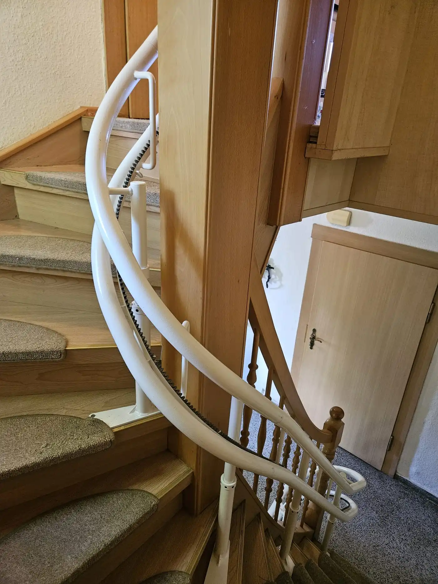 Kurvenlift-Referenz: Treppenlift mit hochgeklapptem Sitz – der Treppenaufgang bleibt frei